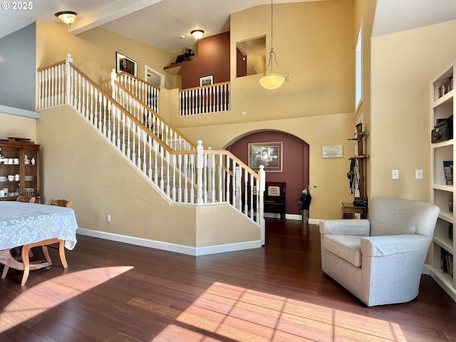 2942 NW Watkins Ct, Camas, WA 98607 - living room with arched walkways, wood finished floors, stairway, a towering ceiling, and built in shelves