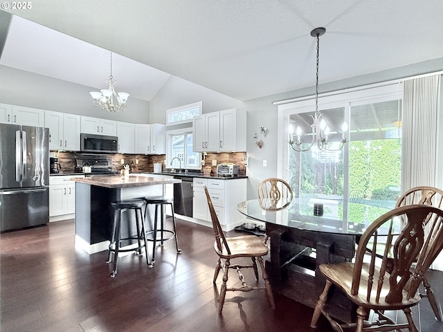 2942 NW Watkins Ct, Camas, WA 98607 - dining space with a chandelier, vaulted ceiling, and dark wood-style flooring