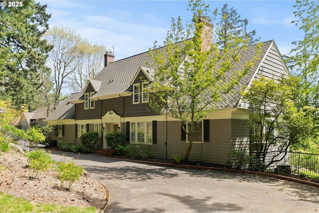 view of front facade featuring fence and a chimney