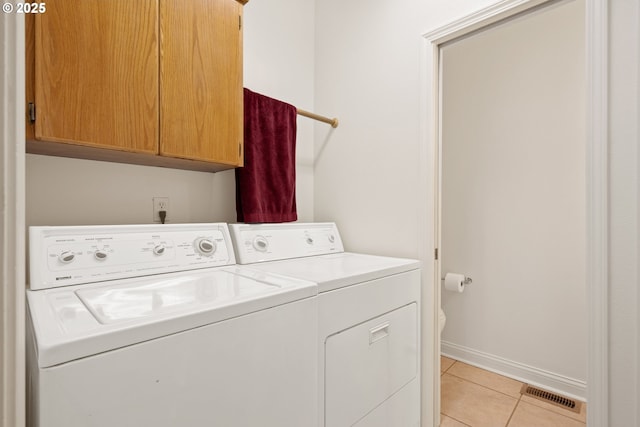 laundry room featuring visible vents, washer and dryer, baseboards, cabinet space, and light tile patterned floors