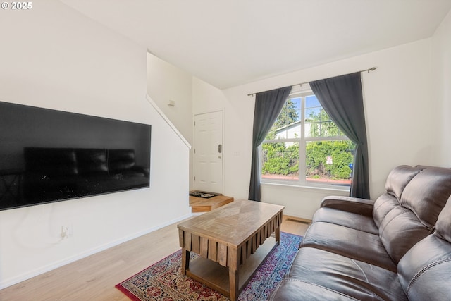 living area featuring baseboards and light wood-type flooring