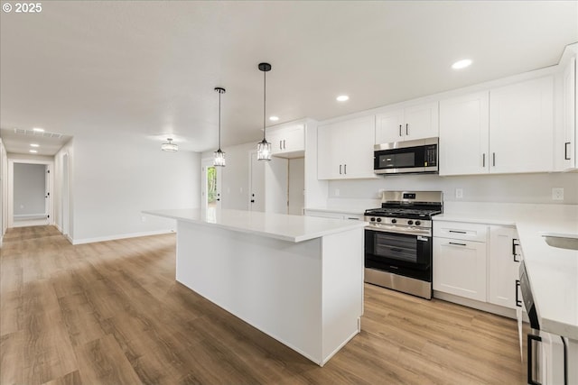 kitchen with recessed lighting, light countertops, white cabinetry, light wood-style flooring, and stainless steel appliances