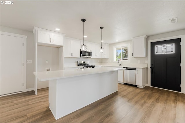 kitchen featuring light countertops, stainless steel appliances, visible vents, and white cabinetry