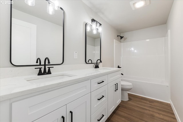 full bathroom featuring double vanity, shower / bath combination, a sink, and wood finished floors