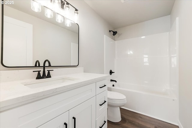 bathroom featuring shower / bathtub combination, toilet, wood finished floors, and vanity