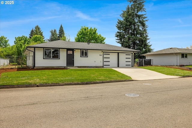 ranch-style home featuring fence, a front lawn, driveway, and a garage