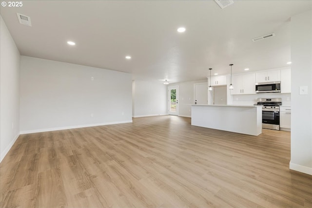 unfurnished living room featuring visible vents, recessed lighting, light wood-style flooring, and baseboards