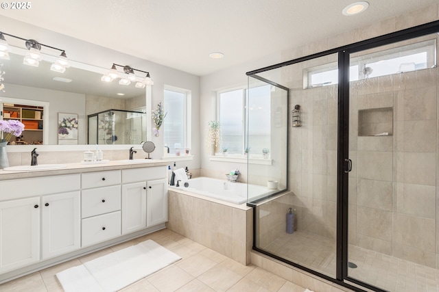 bathroom featuring independent shower and bath, vanity, and tile patterned flooring