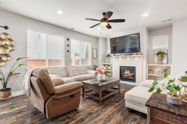 living room featuring dark hardwood / wood-style flooring, a fireplace, and ceiling fan