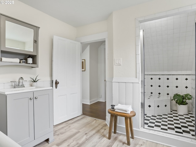 bathroom featuring hardwood / wood-style floors, an enclosed shower, and vanity