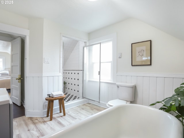 bathroom featuring hardwood / wood-style floors, vaulted ceiling, toilet, and walk in shower