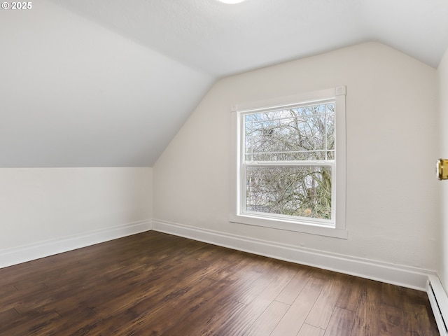 additional living space featuring hardwood / wood-style flooring, a baseboard heating unit, and vaulted ceiling