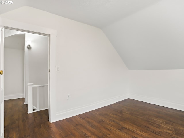 additional living space with vaulted ceiling and dark hardwood / wood-style floors