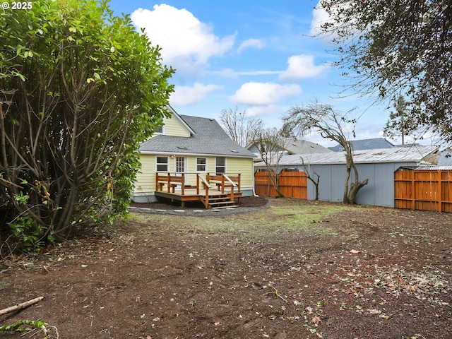 rear view of property featuring a wooden deck