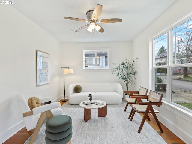 living room with hardwood / wood-style floors, a wealth of natural light, and ceiling fan