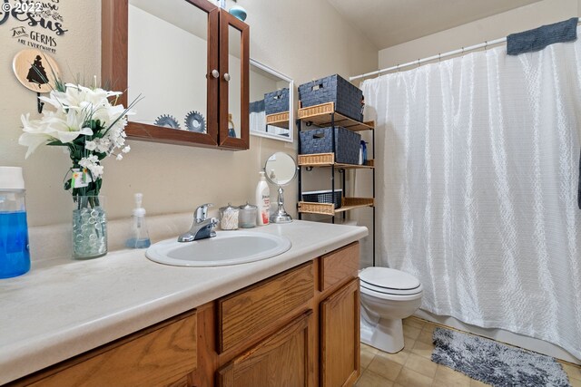 bathroom with tile patterned flooring, vanity, and toilet