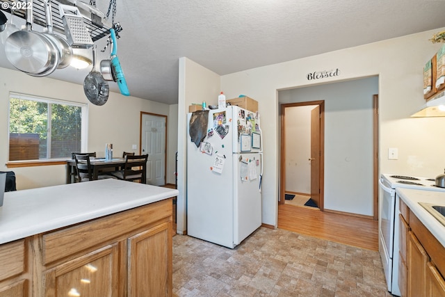 kitchen featuring a textured ceiling and white appliances