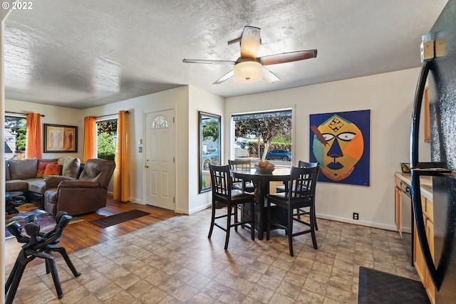 dining space featuring ceiling fan and a textured ceiling