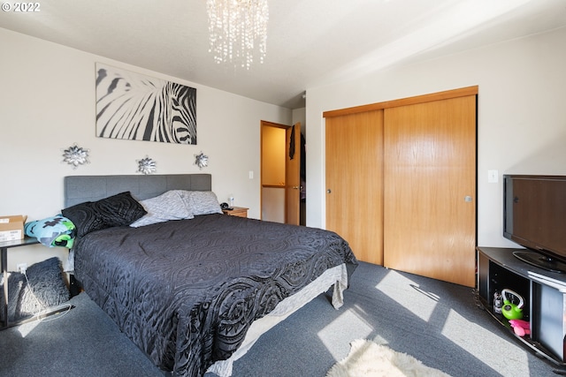 carpeted bedroom with a closet and an inviting chandelier