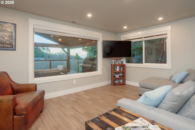 living room with wood finished floors, visible vents, baseboards, recessed lighting, and a textured ceiling