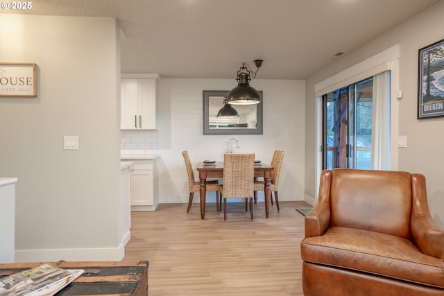 dining room with baseboards and light wood finished floors