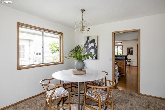 dining room featuring plenty of natural light, a chandelier, and carpet