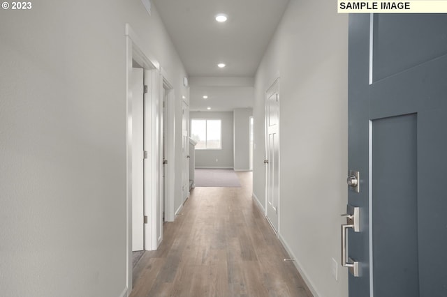 hallway featuring recessed lighting, wood finished floors, and baseboards