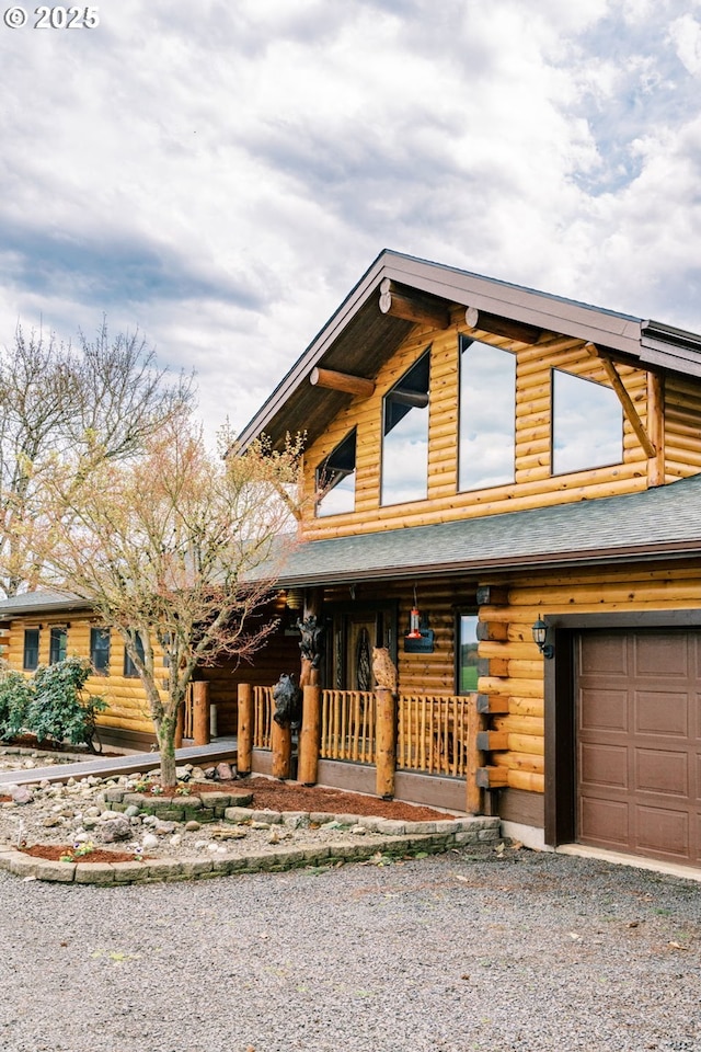 95787 Territorial Hwy, Monroe, OR 97456 - log home featuring covered porch, log exterior, driveway, and a garage