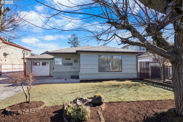 back of property featuring a garage and a lawn