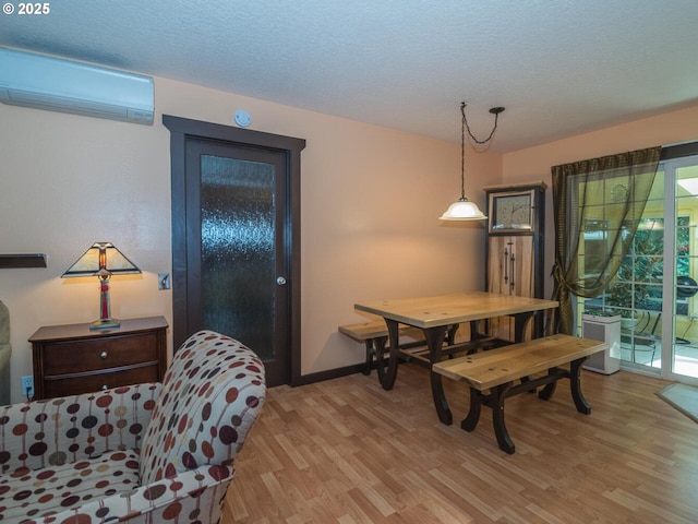 17758 SE Washington St, Portland, OR 97233 - dining space with a wall mounted AC, light wood-style flooring, a textured ceiling, and baseboards