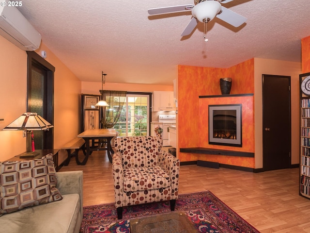 17758 SE Washington St, Portland, OR 97233 - living area with a wall mounted air conditioner, light wood-type flooring, a fireplace, a textured ceiling, and a ceiling fan