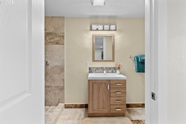 1000 S King St, Seaside, OR 97138 - bathroom with vanity, a tile shower, and decorative backsplash