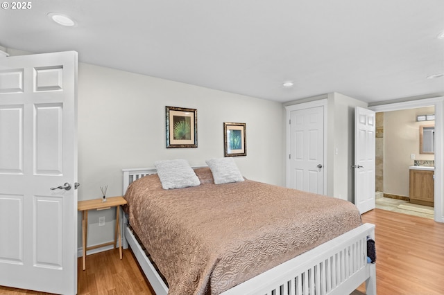 1000 S King St, Seaside, OR 97138 - bedroom with light wood-style flooring, recessed lighting, baseboards, and ensuite bathroom