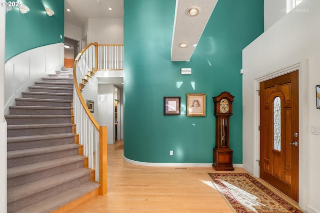 foyer featuring a towering ceiling and light hardwood / wood-style flooring