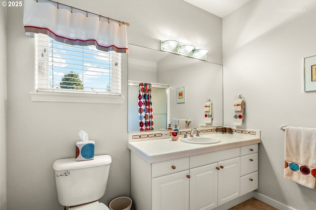 bathroom with vanity, toilet, and walk in shower