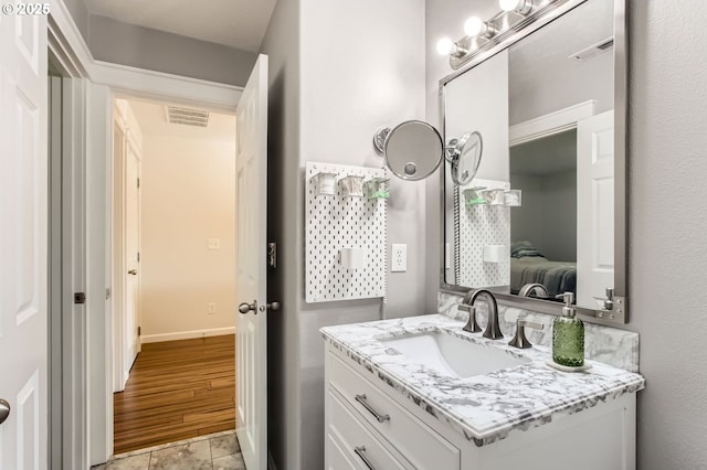 bathroom with visible vents, baseboards, and vanity