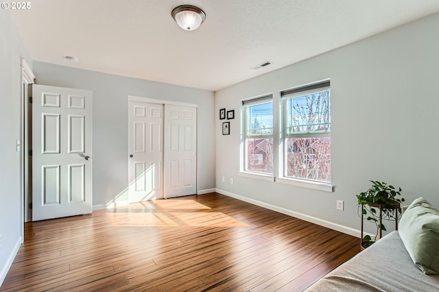 bedroom featuring visible vents, wood-type flooring, and baseboards