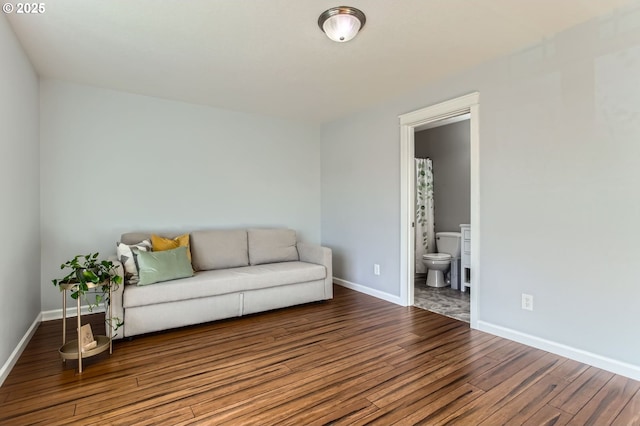 living area with baseboards and wood finished floors