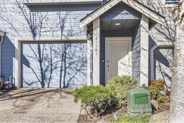 view of exterior entry with a garage and driveway