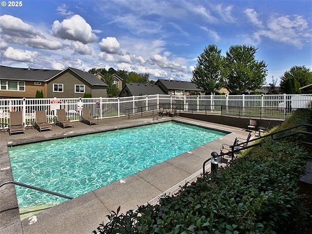 pool with a patio area and fence