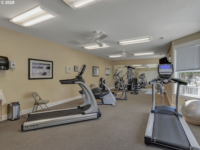 gym with baseboards, visible vents, and ceiling fan