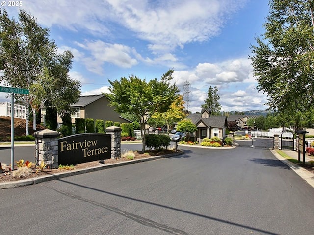 view of road with a gated entry, a residential view, curbs, and a gate