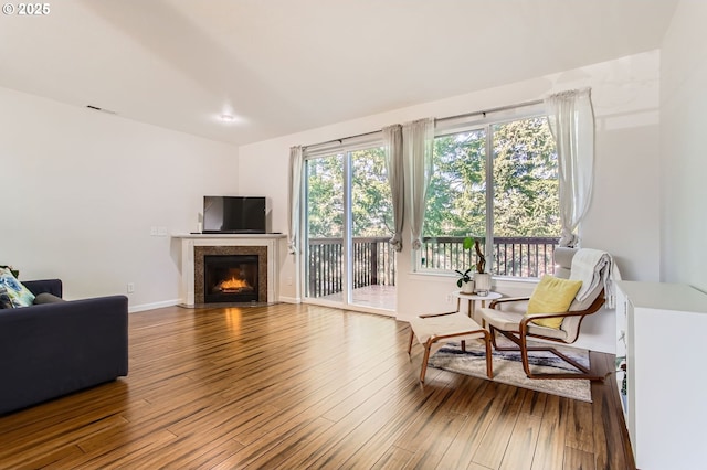 sitting room featuring a high end fireplace, visible vents, baseboards, and hardwood / wood-style flooring