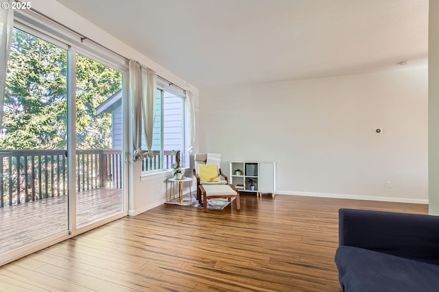 sitting room with baseboards and wood finished floors