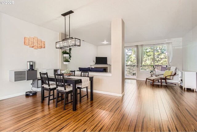 dining room with baseboards, a notable chandelier, and wood finished floors