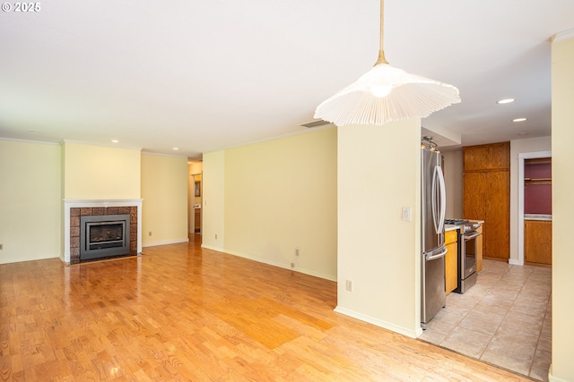 1444 Russet Dr, Eugene, OR 97401 - unfurnished living room featuring recessed lighting, a tiled fireplace, light wood-style floors, and ornamental molding