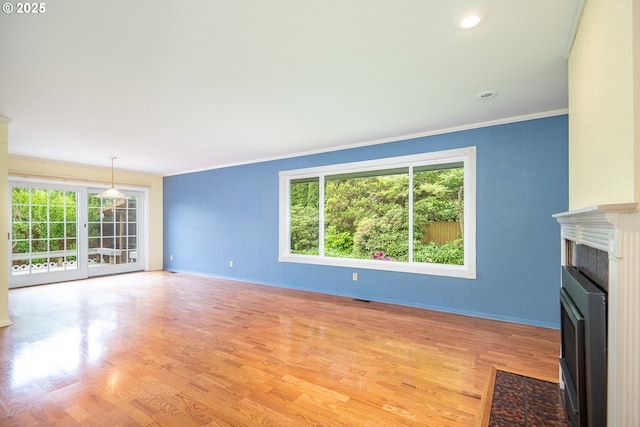 1444 Russet Dr, Eugene, OR 97401 - unfurnished living room featuring crown molding, a fireplace with flush hearth, light wood-style floors, and recessed lighting