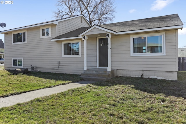 split level home featuring a front yard and roof with shingles