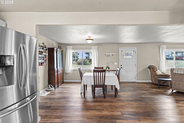 dining area featuring baseboards, dark wood-type flooring, and a textured ceiling