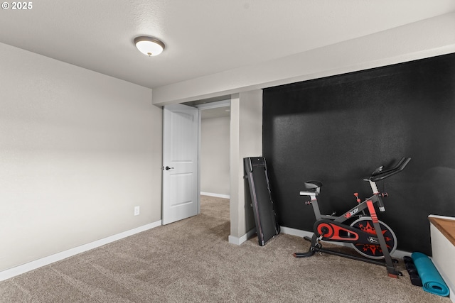 exercise room with baseboards and carpet flooring